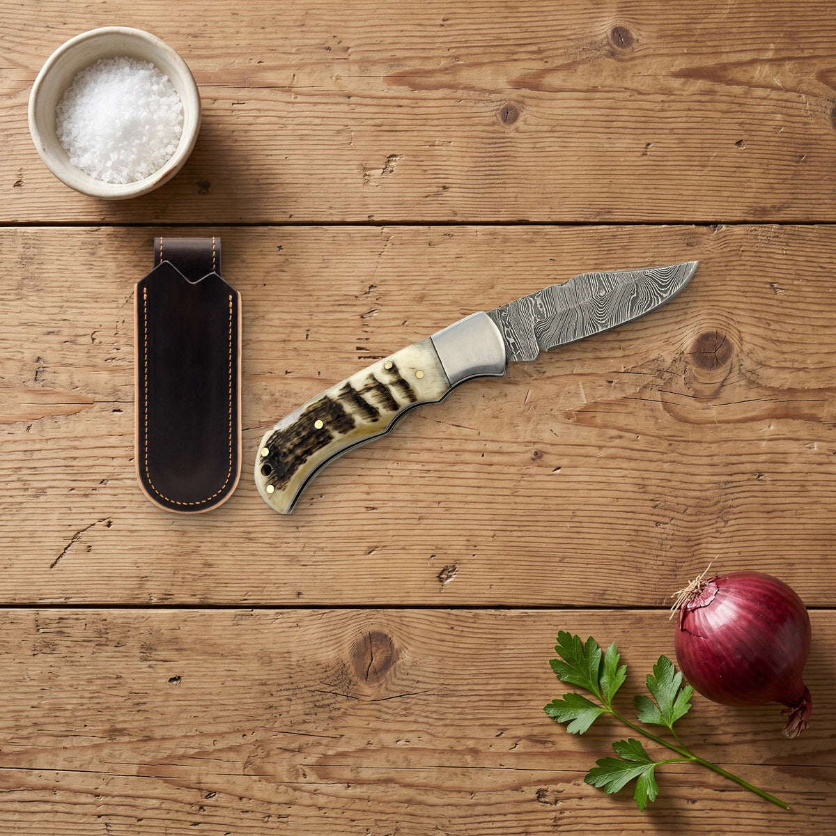 Creek 6.5" Damascus Pocket Knife | Ram Horn, with the Crownridge belt slip in use