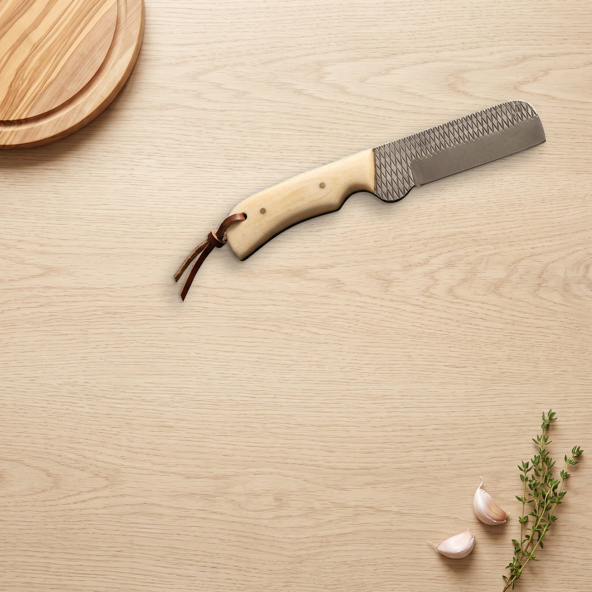 Ranch 7.5" Rasp Steel Bull Cutter | Camel Bone, on a wooden counter